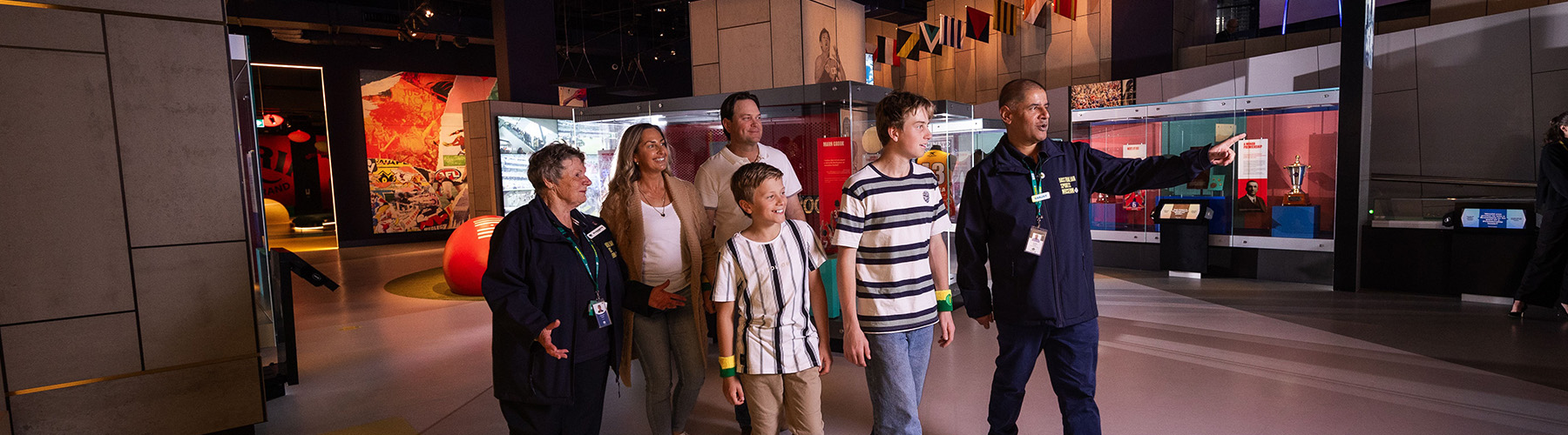 Australian Sports Museum volunteers help a family in the museum