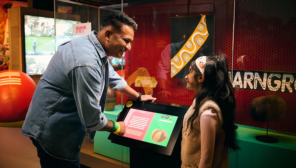 Adult and child exploring an interactive display in the Australian Sports Museum