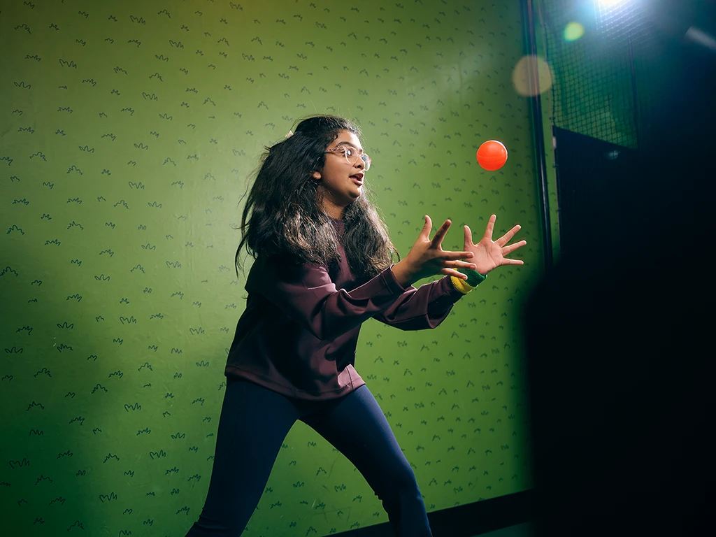 Child playing fast-paced ball game inside