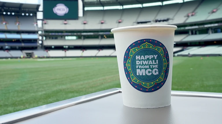 Hot beverage with sticker: Happy from the MCG