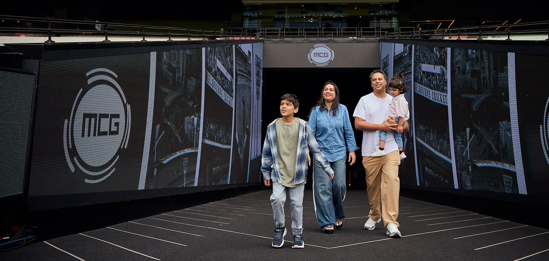 A family walks out excitedly on an MCG tour