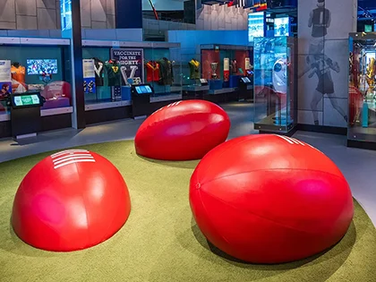 Giant footballs as seats displayed in sports museum.