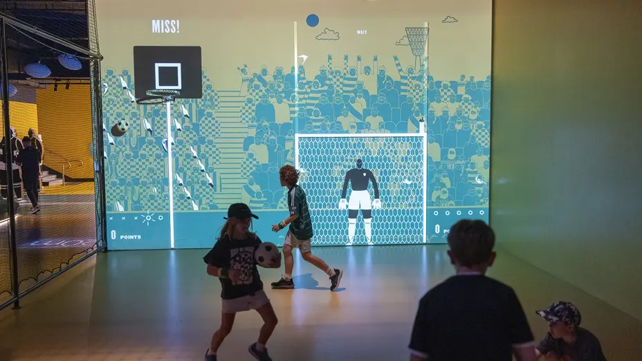 Children playing indoor soccer game with screens