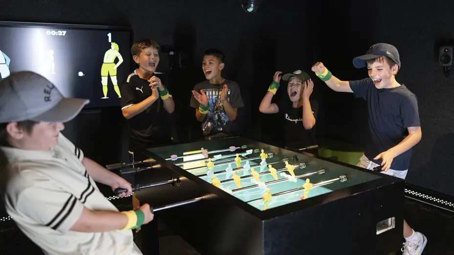Children cheer and play indoor table ball game