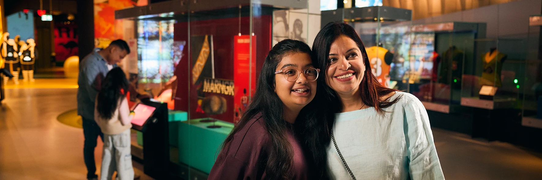 Mother and daughter smiling together inside the Australian Sports Museum