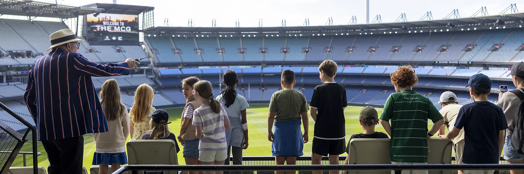 Children take in the view of the MCG from the top level. Stadium is empty.