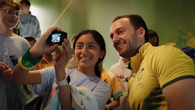School group takes selfie photo with Olympian