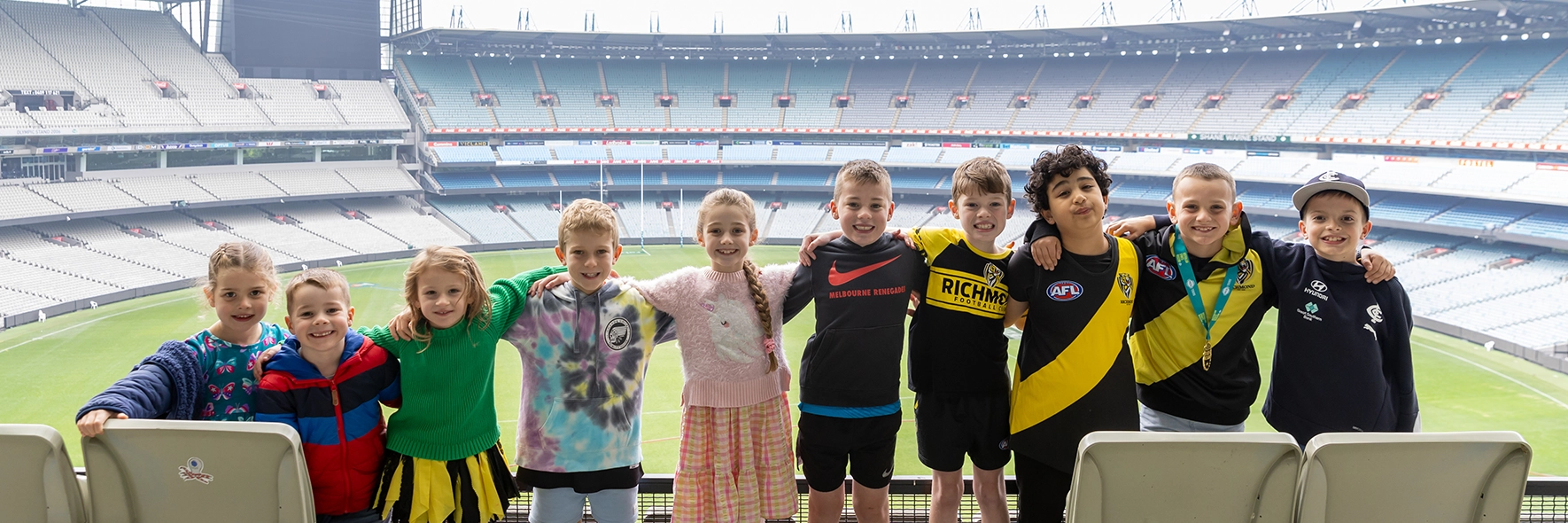 A group of birthday party goers get a group photo on Level 4 of the MCG