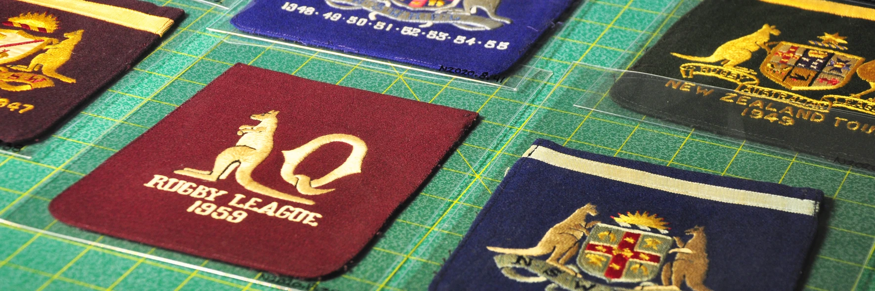 A collection of Rugby League jacket pocket squares with designs on them