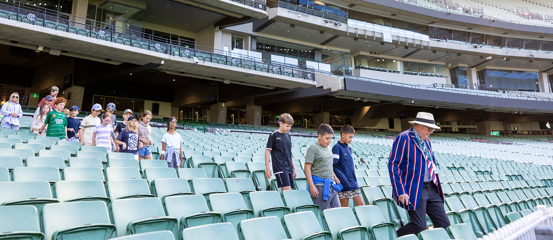An MCG Tour Guide leads a school group into the seating bowl at the MCG