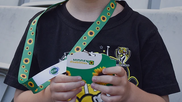 Child wearing hidden disabilities sunflower lanyard and card