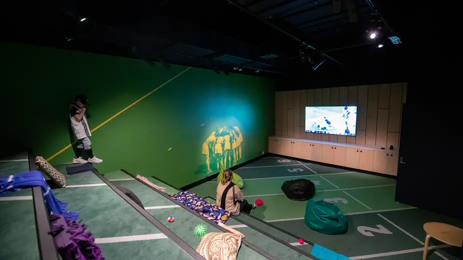 Inside sensory space with beanbags, pillows, fidgets, tiered seating and cinema lighting.