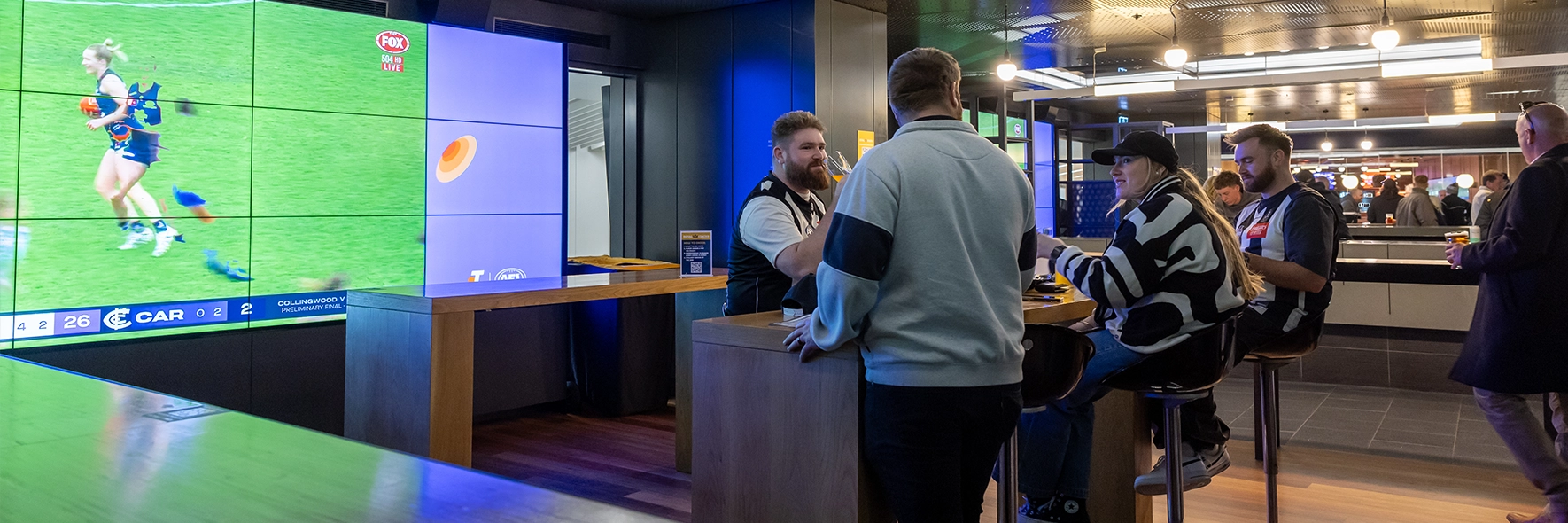 Fans drink beer next to the big screen in the Haydn Bunton Sports Bar at the MCG