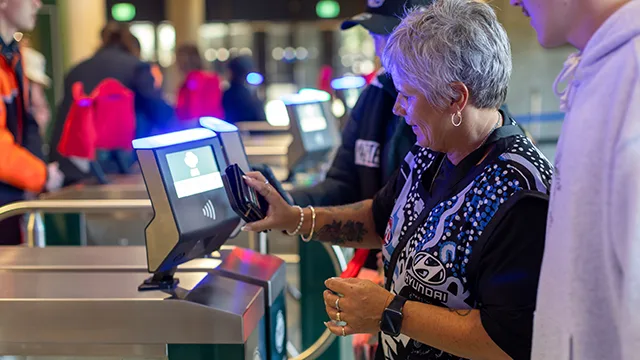 AFL supporter scans a phone against a ticket machine
