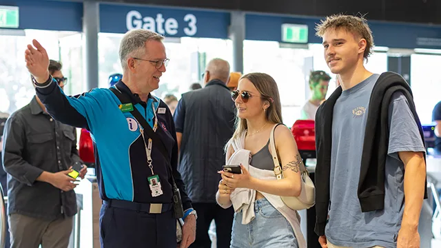 Stadium staff member points out directions to patrons