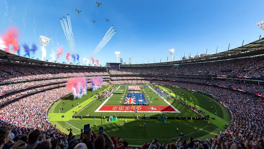 Aircraft fly over a full MCG as the Australian and United States flags are unfurled on the field