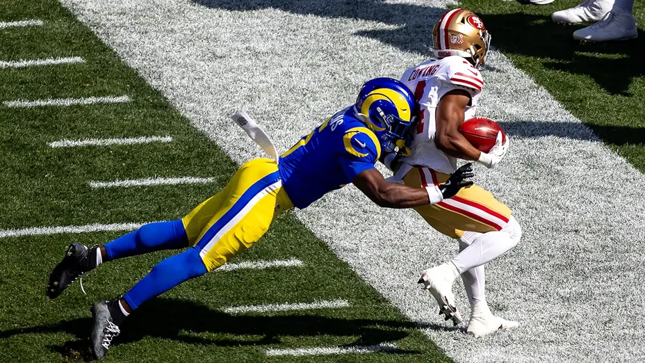 A San Francisco 49ers receiver is tackled by a LA Rams defender
