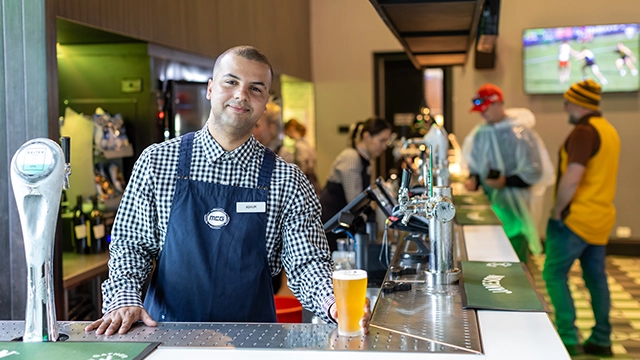 A Delaware North staff member serves a beer at the MCG