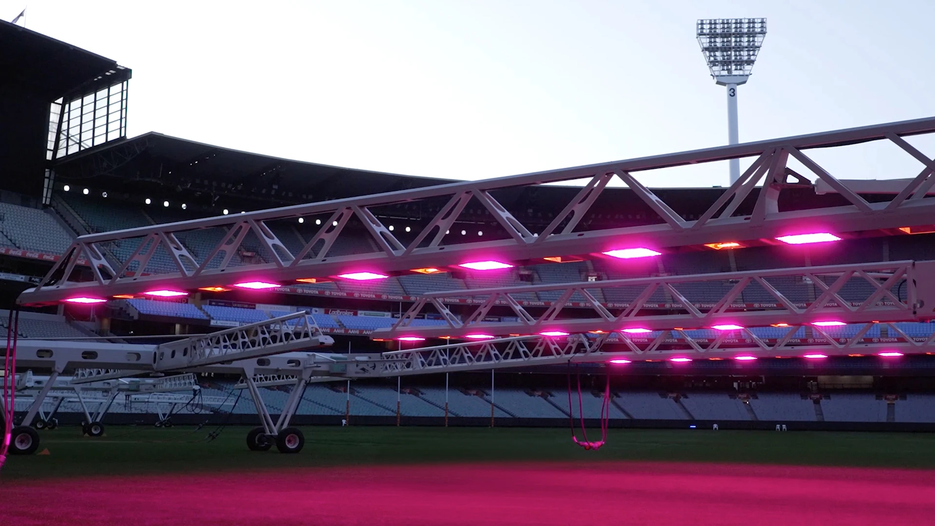 Large lighting rig casts pink light onto MCG turf