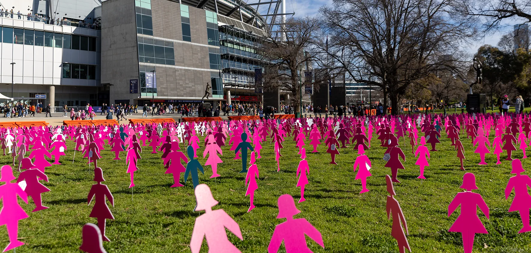 Sea of pink cardboard figures for Breast Cancer Network Australia in the grass outside the MCG