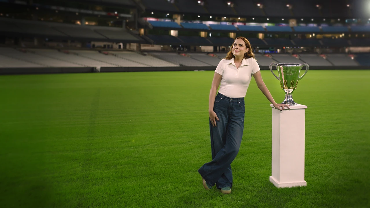 Georgie Tunny stands on the MCG next to the 2026 AFL Premiership Cup