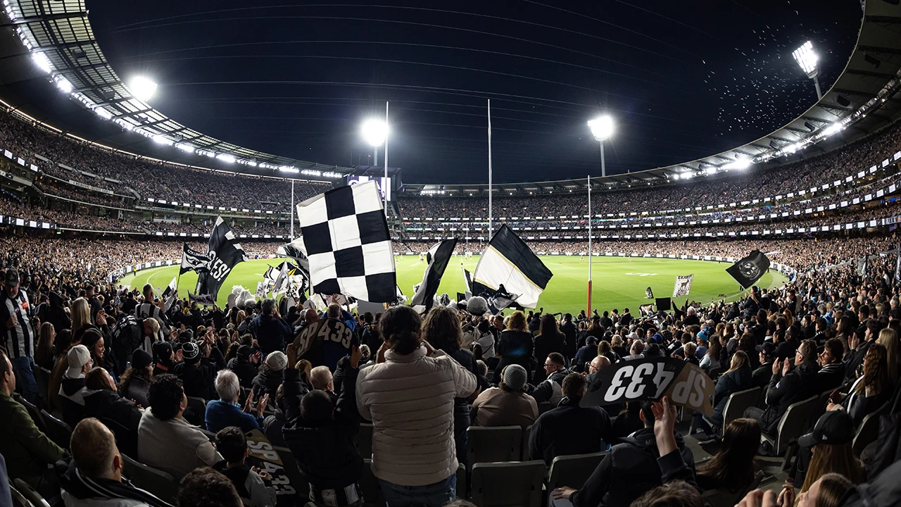 Collingwood fans waving flags from the stands at the MCG